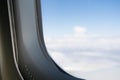 The outside world from the airplane window. Blue sky and white clouds view from grey plane porthole during flight Royalty Free Stock Photo