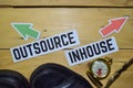 Outsource or Inhouse opposite direction signs with boots,eyeglasses and compass on wooden