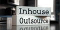 Outsource, inhouse - words on wooden blocks