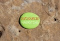 Outsourced marketing symbol. Concept words Outsourced marketing on beautiful green stone. Beautiful red stone background. Business