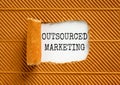 Outsourced marketing symbol. Concept words Outsourced marketing on beautiful white paper. Beautiful brown paper background.