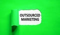 Outsourced marketing symbol. Concept words Outsourced marketing on beautiful white paper. Beautiful green paper background.