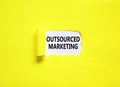 Outsourced marketing symbol. Concept words Outsourced marketing on beautiful white paper. Beautiful yellow paper background.