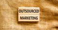 Outsourced marketing symbol. Concept words Outsourced marketing on beautiful wooden blocks. Beautiful canvas table canvas