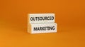 Outsourced marketing symbol. Concept words Outsourced marketing on beautiful wooden blocks. Beautiful orange table orange