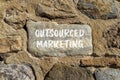 Outsourced marketing symbol. Concept words Outsourced marketing on beautiful grey stone. Beautiful brown stone wall background.