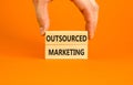 Outsourced marketing symbol. Concept words Outsourced marketing on beautiful wooden blocks. Beautiful orange table orange