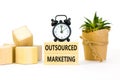 Outsourced marketing symbol. Concept words Outsourced marketing on beautiful wooden blocks. Beautiful white table white background