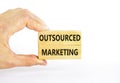 Outsourced marketing symbol. Concept words Outsourced marketing on beautiful wooden blocks. Beautiful white table white background