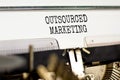 Outsourced marketing symbol. Concept words Outsourced marketing typed on beautiful old retro typewriter. Beautiful white paper