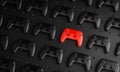 Outstanding Concept. Red Gamepad Between Multiple Black Joysticks Background 3D Rendering