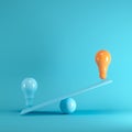 Outstanding Orange light bulb floating on blue seesaw on blue background.