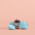 Outstanding silver painted strawberry among blue painted strawberries on pastel pink background Royalty Free Stock Photo
