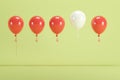 Outstanding white balloon floating among red balloons on green background for copy space