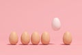 Outstanding white Egg Floating among brown eggs on pink background