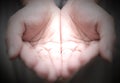 Outstretched cupped hands together of woman - on black background