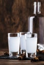 Ouzo - Greek anise brandy, traditional strong alcoholic drink in glasses on the old wooden table, place for text