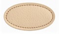 Oval beige leather patch with textured surface and simple stitching on white background Royalty Free Stock Photo