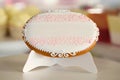 An oval cookie,decorated with glazed pattern on the white stand Royalty Free Stock Photo