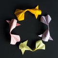 Circular round figure of handmade paper craft origami gold koi carp fishes on black background.Pattern size 1*1, view top