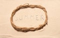 Oval frame of rope with summer lettering drawn on sand
