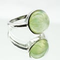 Oval green Prehnite ring put on a white surface