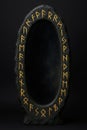 Oval mirror with runic inscriptions on frame Royalty Free Stock Photo