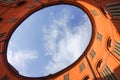 View of blue sky and clouds through oval rooftop of public theater building in Ferrara, Italy for commercial real estate concept Royalty Free Stock Photo