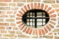 Little round window with cast iron fence in ancient brick wall, Utrecht, the Netherlands Royalty Free Stock Photo
