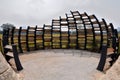 An oval shaped bird hide made of curved dark brown black wooden planks at Singapore Lakeside Gardens