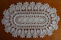 Oval white crochet lace handmade doily on wood