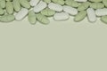 Oval white and green tablets on a white background close up Royalty Free Stock Photo