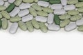 Oval white and green tablets on a white background close-up Royalty Free Stock Photo