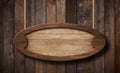 Oval wooden sign hanging on ropes with wood planks background