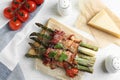 Oven baked asparagus wrapped with bacon on wooden table, flat lay Royalty Free Stock Photo