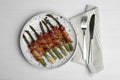 Oven baked asparagus wrapped with bacon on wooden table, flat lay Royalty Free Stock Photo