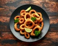 Oven baked breaded calamari rings served with lime wedges, sweet chilli sauce and mayonnaise Royalty Free Stock Photo