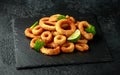 Oven baked breaded calamari rings served with lime wedges, sweet chilli sauce and mayonnaise Royalty Free Stock Photo