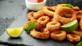 Oven baked breaded calamari rings served with lime wedges, sweet chilli sauce and mayonnaise Royalty Free Stock Photo