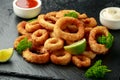 Oven baked breaded calamari rings served with lime wedges, sweet chilli sauce and mayonnaise Royalty Free Stock Photo