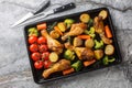 Oven baked chicken drumsticks with fresh baked vegetables close-up on a baking sheet. Horizontal top view Royalty Free Stock Photo