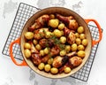 Oven baked Chicken drumsticks and new baby potatoes with thyme in pan, ready to serve