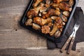 Oven baked chicken legs with onions, garlic and peppers on a dark wooden background closeup. Top view with copy space. Wooden rust Royalty Free Stock Photo