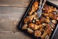 Oven baked chicken legs with onions, garlic and peppers on a dark wooden background closeup. Top view with copy space Royalty Free Stock Photo