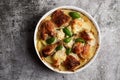 Oven baked chicken with potatoes in sour cream in a white baking dish on a dark grey background Royalty Free Stock Photo
