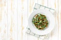 Oven baked green bean casserole sprinkled with crispy fried onions , in white plate on a light wooden table, copy space for text Royalty Free Stock Photo