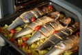 Oven baked sea bass fish with potato and tomatoes Royalty Free Stock Photo