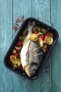 Oven baked whole sea fish with green olives, cherry tomatoes, lemon and herb butter.