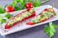 Oven cooked red paprika stuffed with cheese, garlic and herbs on a white plate with parcley and cherry tomatoes an Royalty Free Stock Photo