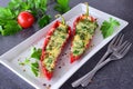 Oven cooked red paprika stuffed with cheese, garlic and herbs on a white plate with parcley and cherry tomatoes an Royalty Free Stock Photo